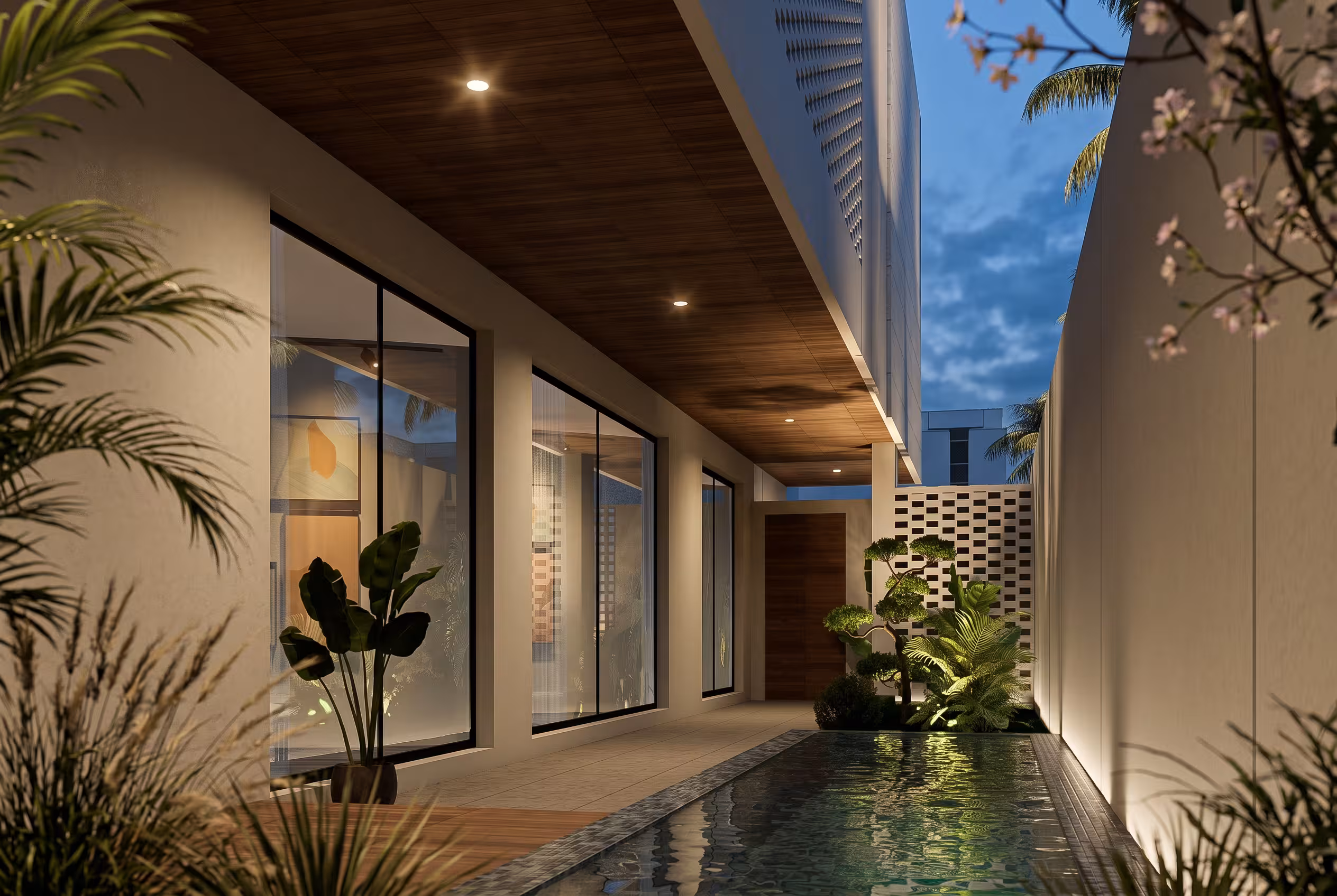 Private internal courtyard with shaded seating, stone paving, lush planting and full-height glazing